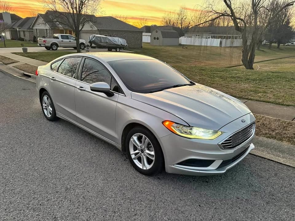 Silver Ford sedan parked on a neighborhood street at sunset